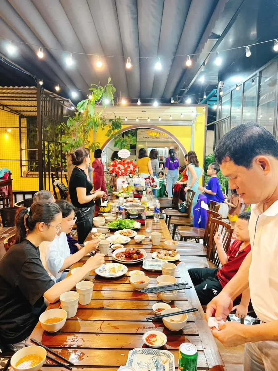 Nhóm khách đông người dùng bữa bên bàn dài tại Ruby Ken