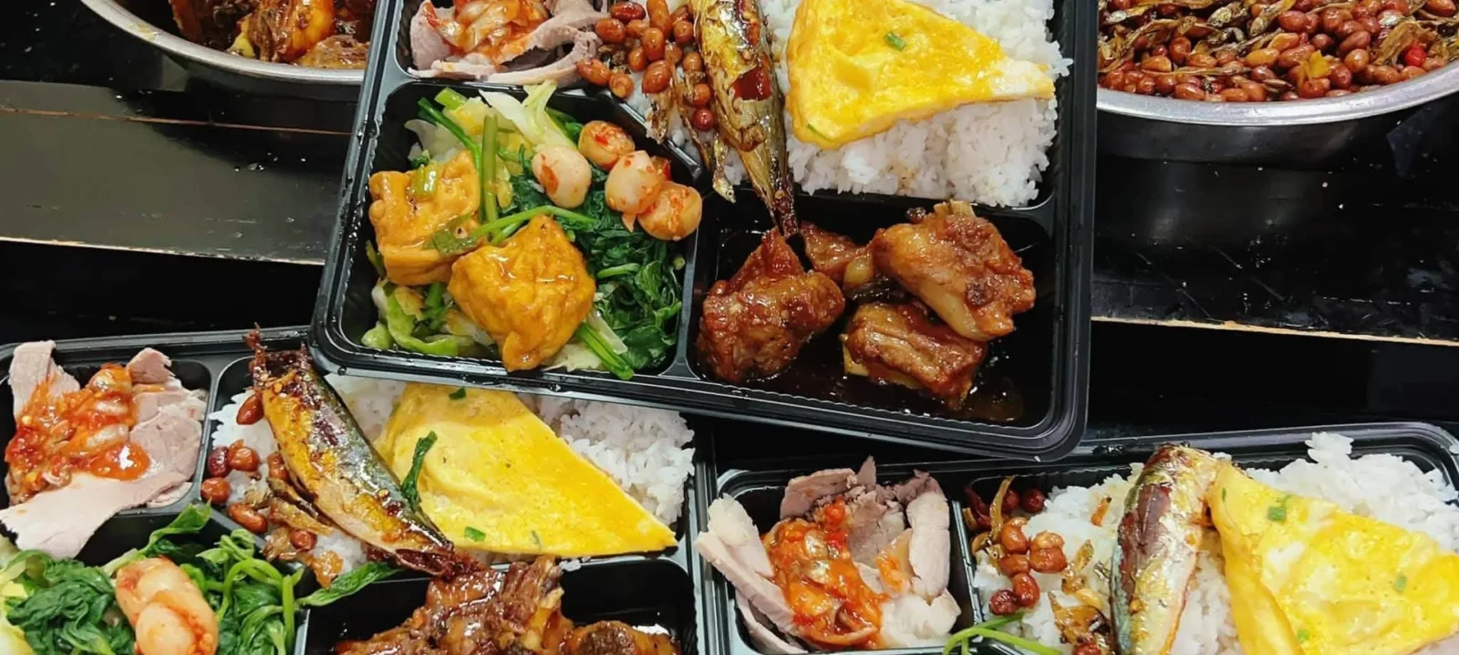 Các suất cơm phần của Ruby Ken với cơm trắng, trứng, rau và món mặn